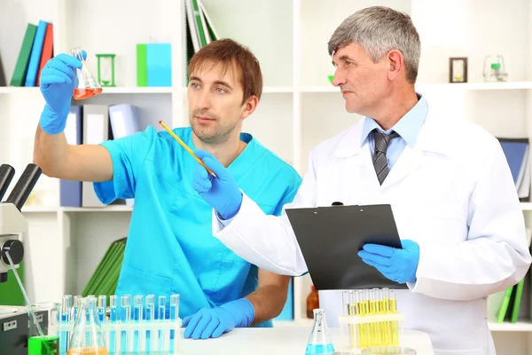 Médico y ensayador durante la investigación sobre el fondo de la habitación — Foto de Stock