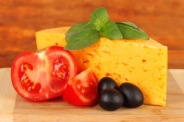 Queso, albahaca y verduras sobre fondo de madera — Foto de Stock