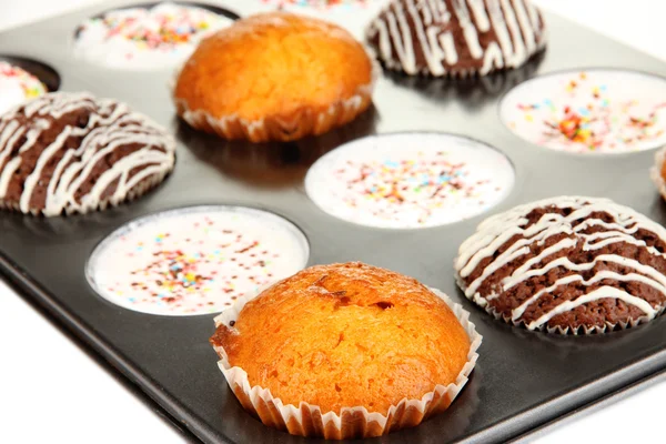 Smakelijke muffin taarten in bakplaat close-up — Stockfoto