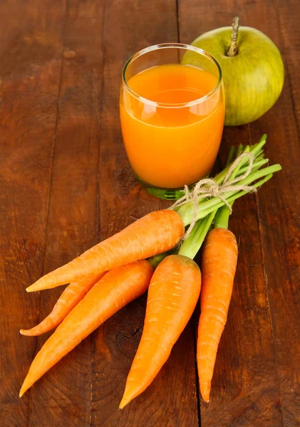 Montón de zanahorias y manzana verde, vaso de jugo, sobre fondo de madera —  Fotos de Stock