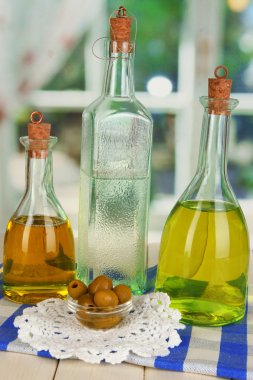 Özgün cam şişeler penceresi arka plan üzerinde ahşap masa üstünde salata sosu ile