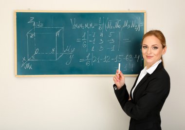 Portrait of teacher woman near the chalkboard in classroom clipart