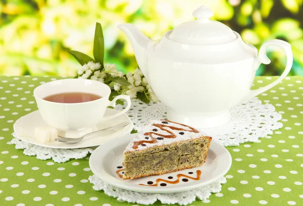 Delicious poppy seed cake with cup of tea on table on bright background — Stock Photo, Image