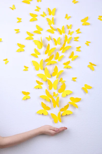 黄色的纸蝴蝶飞向不同的方向在墙上 — 图库照片