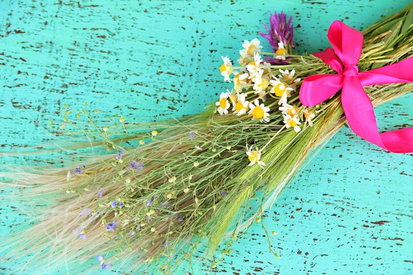 Buquê de flores silvestres e ervas, na cor de fundo de madeira — Fotografia de Stock
