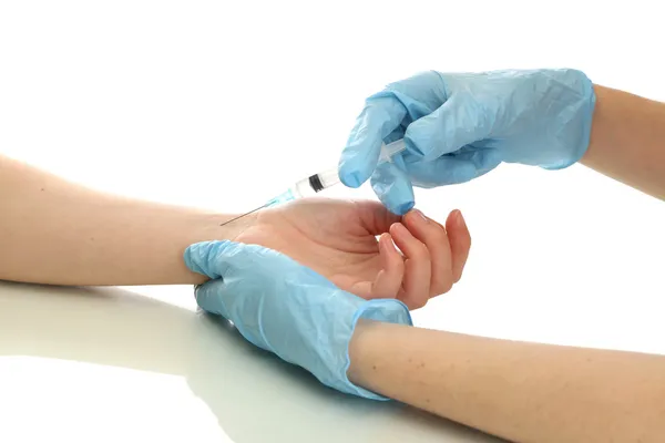 Doktor hospodářství stříkačka s očkovací látkou v pacienta ruce, izolované na bílém — Stock fotografie