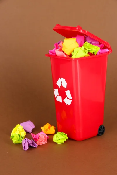 Recycling-Tonne mit Papieren auf braunem Hintergrund — Stockfoto