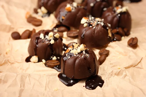 チョコレート菓子、コーヒー豆、ベージュの用紙の背景 — ストック写真