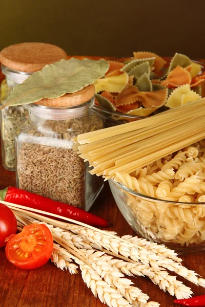 Різні види макаронних виробів, спецій, помідорів на дерев'яному столі — стокове фото