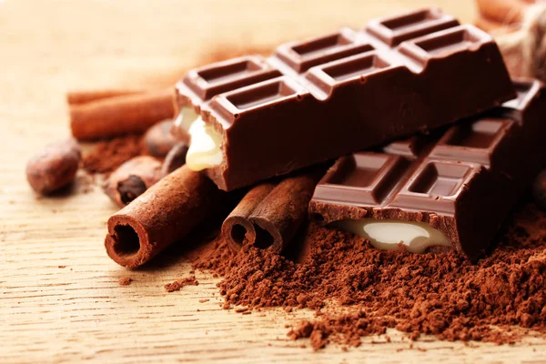 Sammansättningen av choklad godis, kakao och kryddor på trä bakgrund — Stockfoto