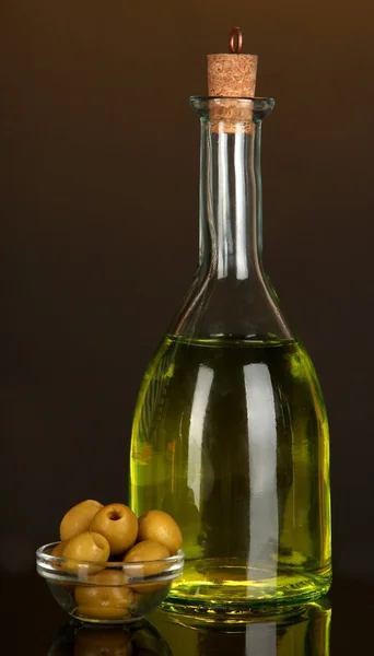Original glass bottle with oil on dark color background — Stock Photo, Image