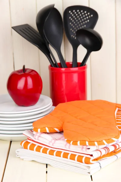 Paramètres de cuisine : ustensile, poignées, serviettes et autres sur une table en bois — Photo