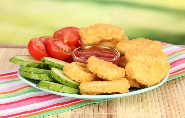 Gebakken kipnuggets met groenten en saus op tafel in park — Stockfoto