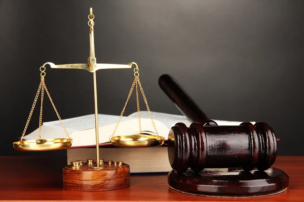 Wooden gavel, golden scales of justice and books on grey background — Stock Photo, Image