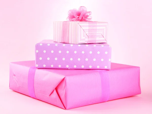 Яркие подарки с бантами на розовом фоне — стоковое фото