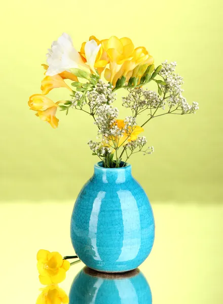 Vacker bukett av fresia i vas på grön bakgrund — Stockfoto