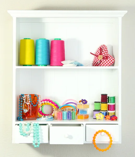 Beautiful white shelves with thread and material for handicrafts — Stockfoto