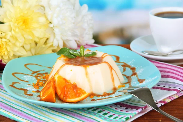 Panna Cotta with orange zest and caramel sauce, on color wooden background — Stock Photo, Image