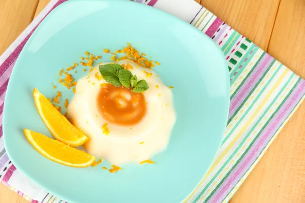 Panna Cotta with orange zest and caramel sauce, on wooden background — Stock Photo, Image