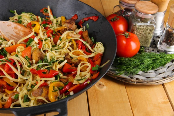 Noodles with vegetables on wok on wooden background — Stock Photo, Image