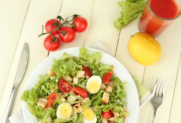 Caesarsalade op witte plaat, op een houten achtergrond kleur — Stockfoto