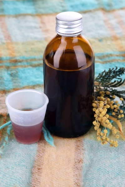 Cough syrup on knitted scarf close-up — Stock Photo, Image