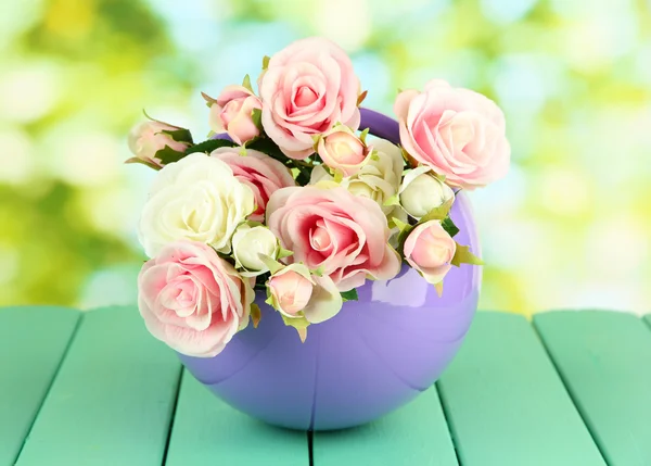 Pot with flowers on a wooden table on the nature background