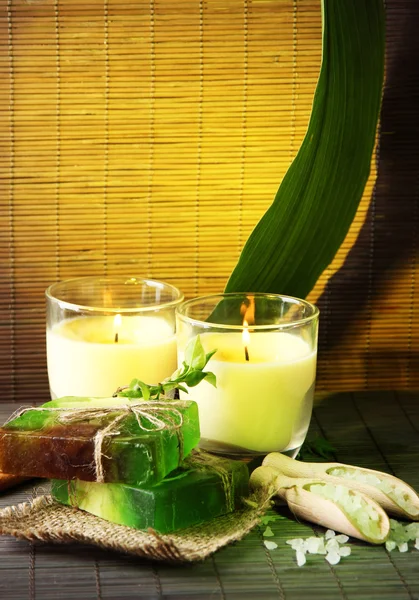 Jabón y velas hechas a mano sobre fondo de bambú — Foto de Stock
