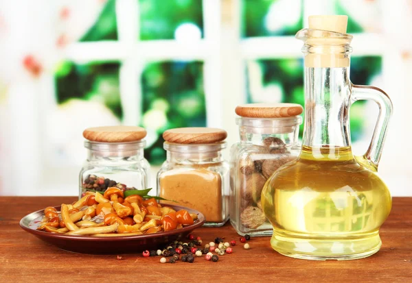 Composition of delicious marinated mushrooms, oil and spices on wooden table on bright background — Stock Photo, Image