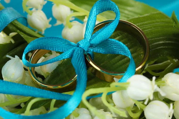花の背景上のリボンで縛ら結婚指輪 — ストック写真