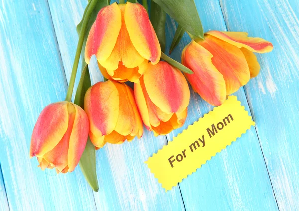 Красиві помаранчеві тюльпани на кольоровому дерев'яному фоні — стокове фото