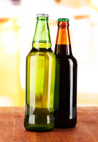 Bier in flessen op tafel op kamer achtergrond — Stockfoto