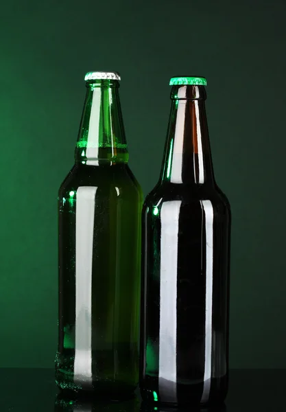 Garrafas de cerveja no fundo verde — Fotografia de Stock