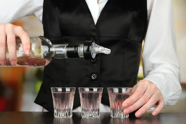 明るい背景上のグラスに注いで飲料のボトルとバルメン手 — ストック写真