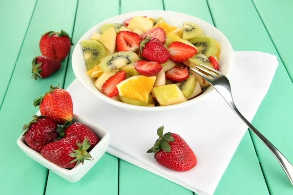 Nuttige fruitsalade van vers fruit en bessen in kom op servet op houten tafel close-up — Stockfoto