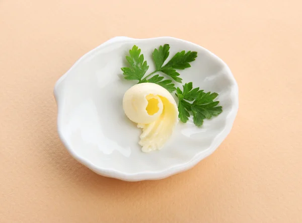 Buttercurl auf Teller auf beigem Hintergrund — Stockfoto