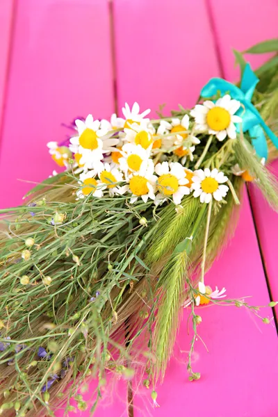 Bouquet di fiori selvatici ed erbe aromatiche, su sfondo di legno a colori — Foto Stock