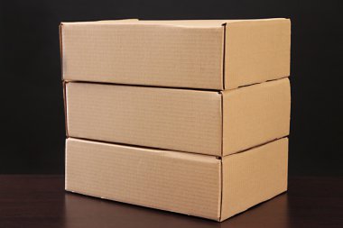 siyah arka plan üzerine ahşap masa üstünde parsel
