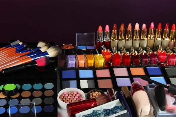 Багато різних косметичних засобів на фіолетовому фоні — стокове фото