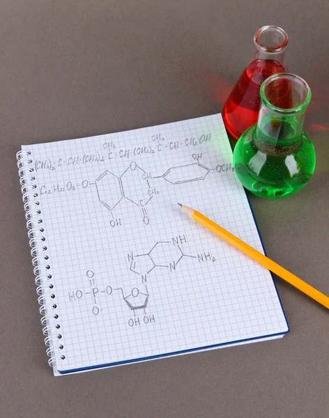 Test buizen met kleurrijke vloeistoffen en formules op grijze achtergrond — Stockfoto