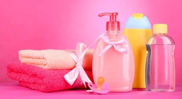 Baby cosmetics and towels on pink background — Stock Photo, Image