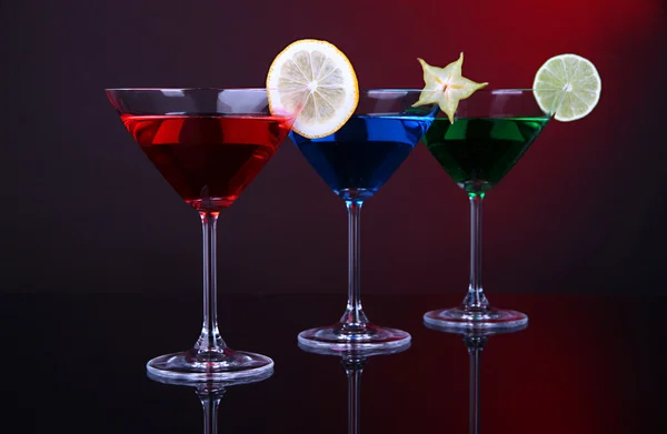 Alcoholic cocktails in martini glasses on dark red background — Stock Photo, Image