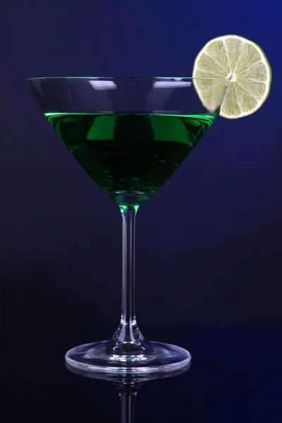 Green cocktail in martini glass on dark blue background — Stock Photo, Image
