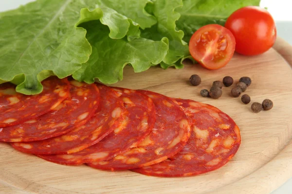 Salami slices on wooden board, close up — Stock Photo, Image