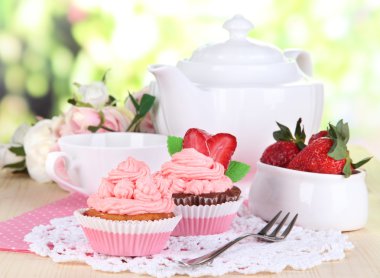 güzel çilekli kek ve doğal zemin üzerine yemek masası üzerinde aromalı çay