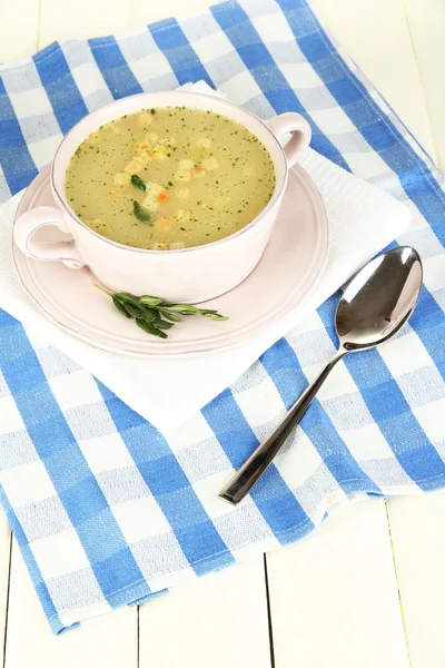 Nourishing soup in pink pan on wooden table close-up — Stock Photo, Image