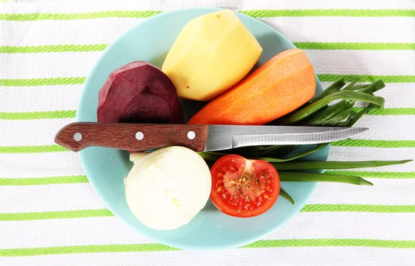 Peeled vegetables on plate on napkin — Stock Photo, Image