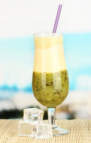 Delicious fruit smoothie on table on blue background — Stock Photo, Image