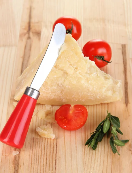 Piece of Parmesan cheese with knife on wooden table close-up — Stock Photo, Image