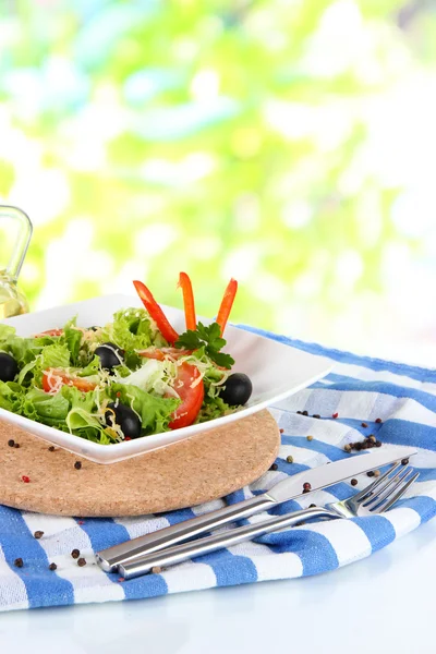 Light salad on plate on napkin on window background — Stock Photo, Image